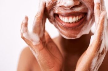woman smiling washing face